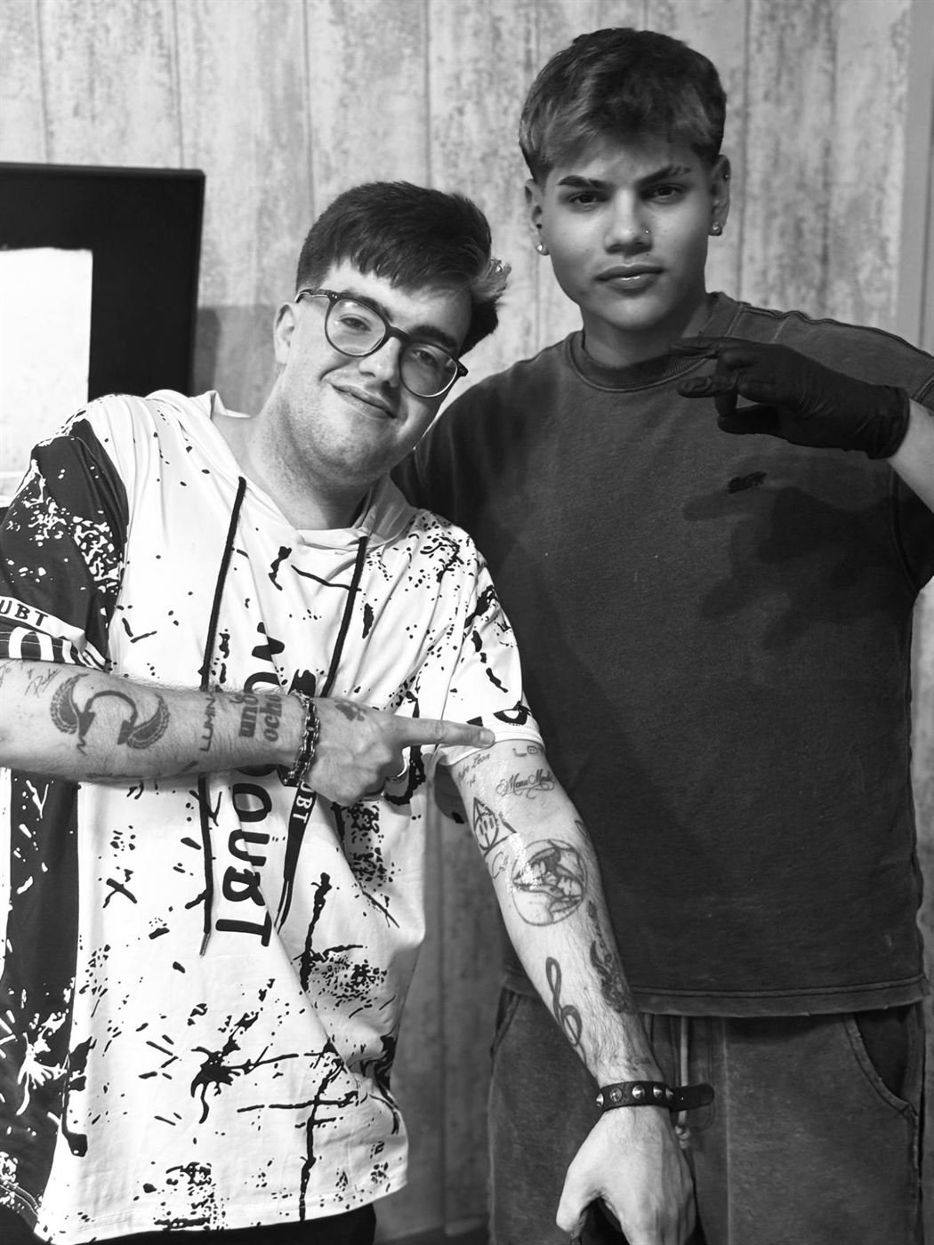 Cliente enseñando sus tatuajes recién hechos junto al tatuador